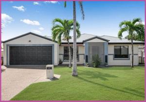 a house with palm trees and a garage at Sarina Court 8 in Ross River