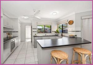 a kitchen with a counter and two chairs in it at Mount Louisa Magic in Ross River