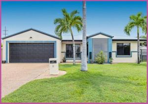 a house with palm trees and a garage at Mount Louisa Magic in Ross River +3 photos