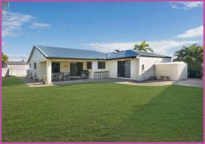 a white house with a large lawn in front of it at Mount Louisa Magic in Ross River