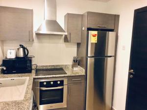 a kitchen with a stainless steel refrigerator and a stove at The Gallery by Luxury Stay in Accra