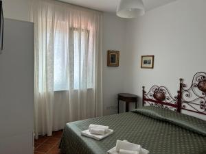 ein Schlafzimmer mit einem grünen Bett und einem Fenster in der Unterkunft La Veduta in Praia a Mare