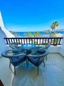 un tavolo e sedie su un balcone con vista sull'oceano di Parque Santiago 2 Pure Home Tenerife ad Arona