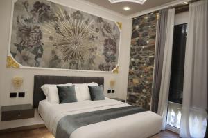 um quarto com uma cama com uma grande pintura na parede em Queen Cattleya Suite em Génova