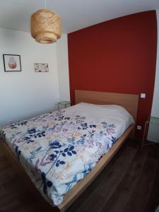 a bedroom with a bed with a floral comforter at Chez Louise et Juliette in Vallon-Pont-dʼArc