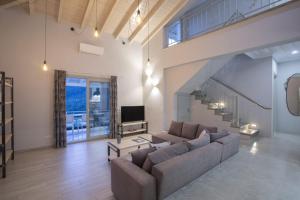a large living room with a couch and a tv at Panoutsis Villa - Sivros Lefkada in Sívros