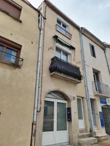 un edificio con porta e balcone di Moderne et chaleureux duplex en centre-ville a Saint-Jean-de-Védas