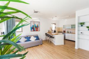 ein Wohnzimmer mit einem Sofa und einer Küche in der Unterkunft One Step from the Sea. Apartment 5 +parking. in Tel Aviv