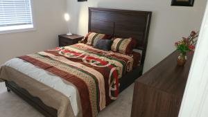 a bedroom with a bed and a wooden headboard at Beautiful Master Bedroom, TV, Wi-fi, Laundry, Parking in Cambridge