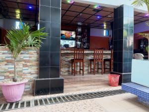 Gloton apartments في Sere Kunda: بار في مطعم مع كراسي خشبية
