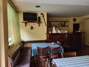 a dining room with a table and chairs and a television at Guest house Skabrin in Bansko