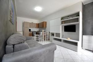 a living room with a gray couch and a kitchen at La casa di Metis in Agerola