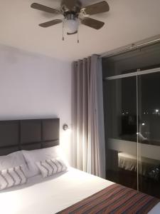 1 dormitorio con 1 cama y ventilador de techo en Casa Yuraq Hotel Boutique en Chincha Alta