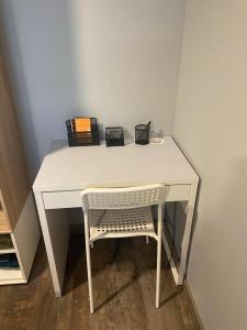 a white desk with a chair next to a wall at Appartement 2 pièces cozy au calme in Mitry-Mory