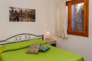 uma cama verde com duas amarras em cima em Casa Ginepro em Olbia