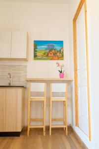 a kitchen with a table and two stools at Ofim Holidays in Ambohidratrimo