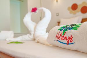 a white towel with a happy holidays sign on a couch at Ofim Holidays in Ambohidratrimo