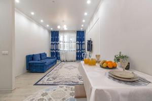 een woonkamer met een tafel en een blauwe bank bij Евродвушка в ЖК Orynbor Towers in Astana