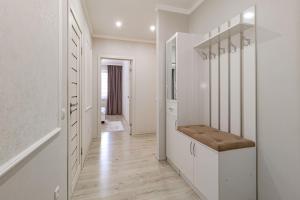 een witte gang met een kast met een bankje bij Евродвушка в ЖК Orynbor Towers in Astana +16 foto's