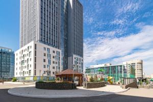 een groep hoge gebouwen met een prieel in een stad bij Евродвушка в ЖК Orynbor Towers in Astana