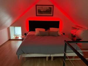 Schlafzimmer mit einem Bett mit roter Decke in der Unterkunft Cottage cocooning romantique avec jaccuzzi privé in Ancinnes