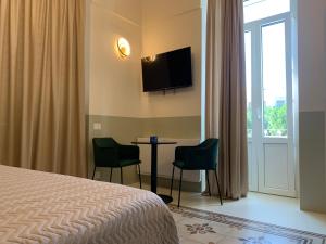 una camera d'albergo con letto, tavolo e sedie di Il Sogno di Mimì a Polignano a Mare