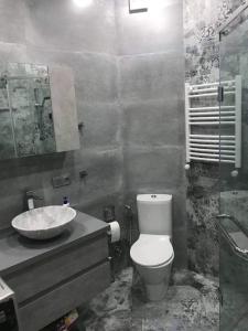 y baño con aseo y lavamanos. en Sweet house en Batumi