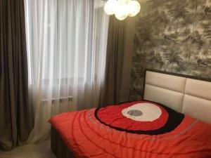 1 dormitorio con 1 cama con edredón rojo en Sweet house en Batumi