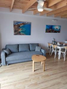 a living room with a blue couch and a table at Baltic Rafa in Niechorze