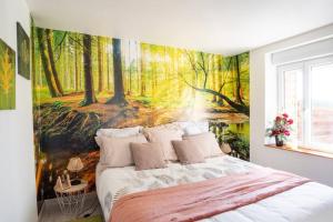 a bedroom with a forest mural on the wall at Relaxing cottage bain nordique in Ancinnes