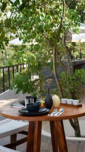 a wooden table with plates and utensils on it at Eterna Tulum in Tulum