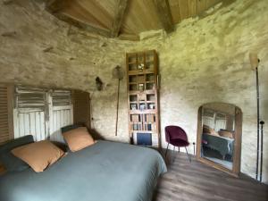 a bedroom with a large bed and a mirror at Le Colombier de Malpas in Quingey