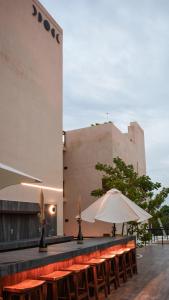 a row of tables with an umbrella and a building at Eterna Tulum in Tulum