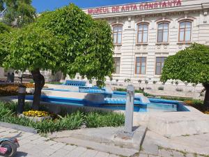 a building with a bunch of blue benches in front of it at MIANELLY CENTER 3 in Constanţa