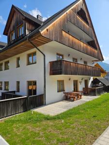 a house with a wooden roof with a picnic table at Apartma Lenka Kranjska Gora in Kranjska Gora