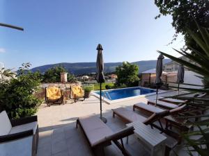 a villa with a swimming pool and a patio with umbrellas at Al Mare in Igalo