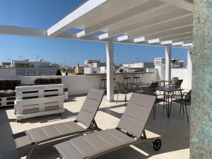 a patio with chairs and tables on a roof at Il Sogno di Mimì in Polignano a Mare