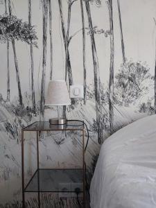 a bedroom with a drawing of trees on the wall at Maison de ville 6 couchages au centre de Lège bourg in Lège-Cap-Ferret