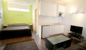 a small room with a bed and a kitchen at Ultimate Apartments Bondi Beach in Sydney