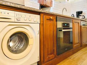 y cocina con lavadora y encimera. en Exquisitely renovated and centrally located apartment with free parking, en Turín