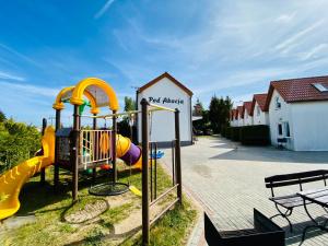 a playground with a yellow slide and a slideintend at Pod Akacją in Rewal