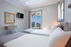 a hotel room with two beds and a window at Panoutsis Villa - Sivros Lefkada in Sívros +35 photos