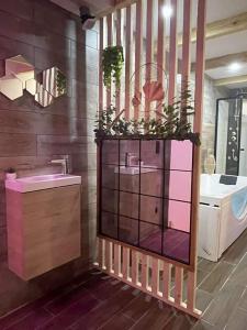 une salle de bain avec un lavabo et un meuble rose dans l'établissement La Belle Echapée, à Bassan