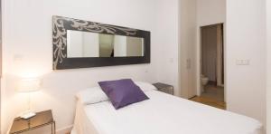 1 dormitorio con cama blanca y espejo en My City Home - Hermoso apartamento en Calle Iriarte en Madrid