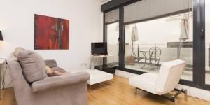 マドリードにあるMy City Home - Hermoso apartamento en Calle Iriarteのリビングルーム(ソファ、椅子付)