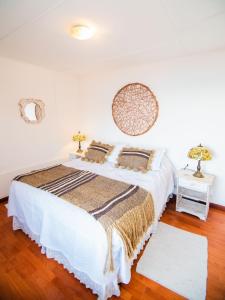 - une chambre avec un grand lit blanc et deux lampes dans l'établissement Amigos del viento, à Chile Chico
