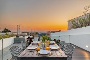 a wooden table on a balcony with a view of the ocean at Portugal Active Sunset Beach Lodge in Carreço