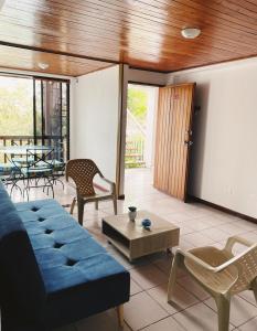 uma sala de estar com um sofá azul e cadeiras em APARTAMENTO EN PLAYA DECAMERON em Santa Marta