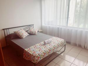 um pequeno quarto com uma cama e uma janela em APARTAMENTO EN PLAYA DECAMERON em Santa Marta