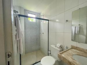 a bathroom with a shower and a toilet and a sink at Pousada Talha - Mar in Maragogi